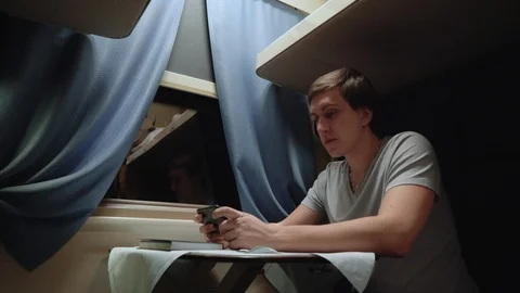 A man reads an e-book on the phone in a train. Stock Footage 105259667