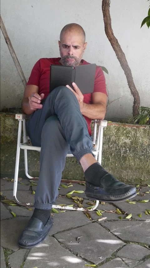 A man reads an e-reader. A person reads an e-book on their e-reader Video stock 321500709