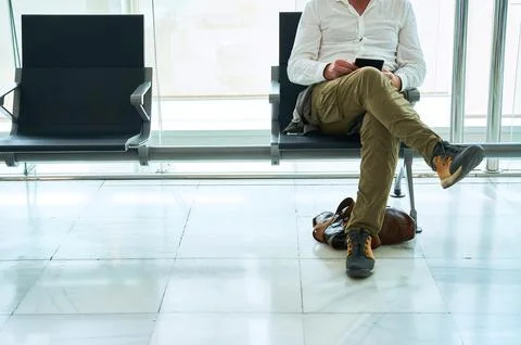 Man reads an electronic book while waiting sitting in a seat Stock Photos