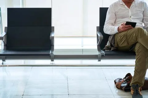 Man reads an electronic book while waiting sitting in an airport lounge Stock Photos