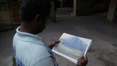 Man-reads-an-ikea-print-advertisement-in-newspaper-on-Ikea-india-launch-day Stock Footage 102291531