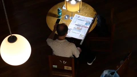 A man reads newspaper in library Stock Footage 255369791