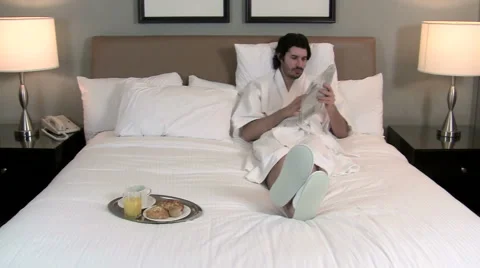 Man reads paper / breakfast in bed V1 - HD Stock Footage 1004438