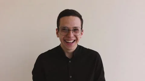 Man reads a script and laughs standing on a beige background Stock Footage 142208775