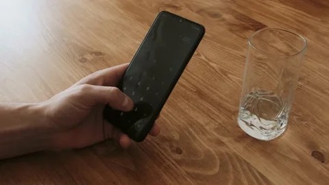 Man reads text from the phone on the background of a wooden table Stock Footage 151690840