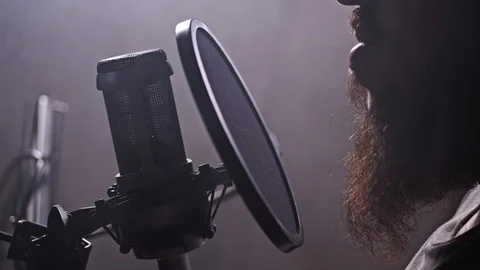 A man reads text in a recording studio. Close-up mouth and microphone. 4K Slow Video stock 105287395