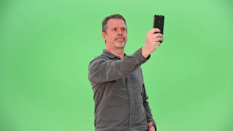 Man receiving a cell phone call with reception problems isolated on green screen 動画素材 100101021