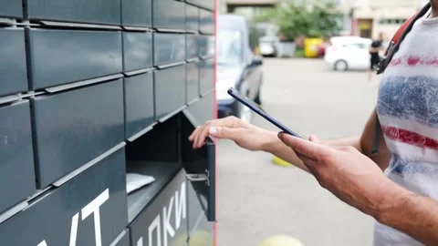 Man receiving parcel from post terminal machine using smartphone outdoors. 스톡 동영상 249962477