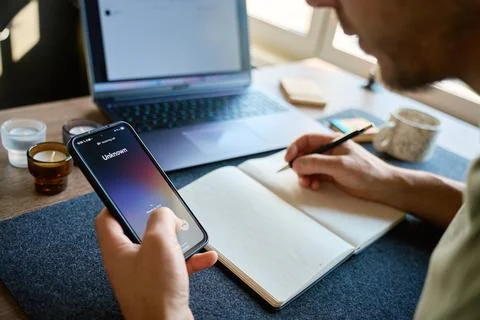 Man receiving unknown call while writing at desk Stock Photos
