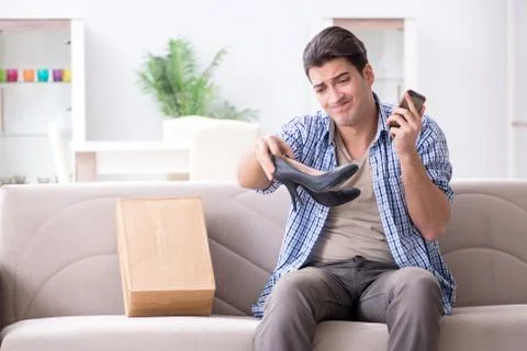 Man receiving wrong parcel with female woman shoes 库存照片
