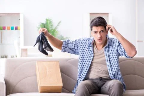 Man receiving wrong parcel with female woman shoes Stockfoto's