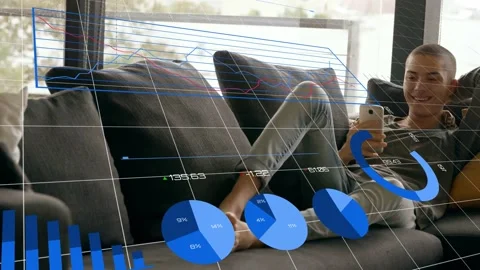 Man reclining on couch tapping phone and checking finance data, animated charts Stock Footage 333288098