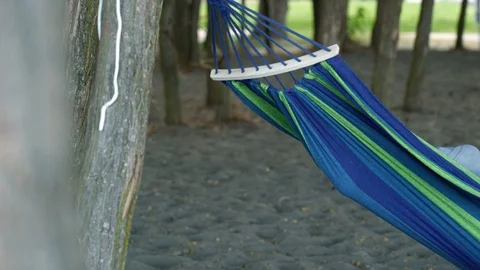 Man reclining in hammock using digital tablet 動画素材 88021924