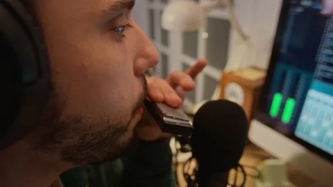 Man Recording Harmonica Solo with Microphone in Home Music Studio Vidéo 337499931
