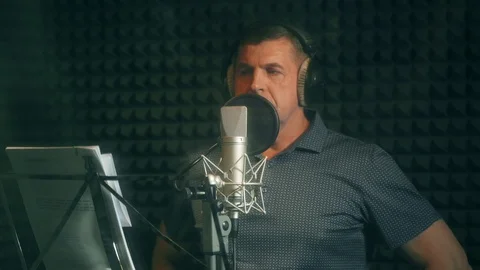 Man In Recording Studio Talking Into Microphone. View through the glass. Stock Footage 107359340