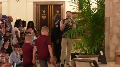 Man recording video of diverse group in hotel lobby Stock Footage 336349968