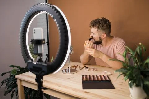 Man recording video vlog while applying cosmetics or explore cosmetic product Stock Photos