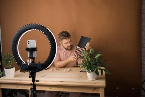 Man recording video vlog while applying cosmetics or explore cosmetic product Stock Photos