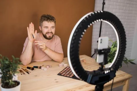 Man recording video vlog while applying cosmetics or explore cosmetic product Stock Photos