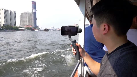 Man recording view on smartphone while sailing on the river, slow motion shot  Stock Footage 88154735