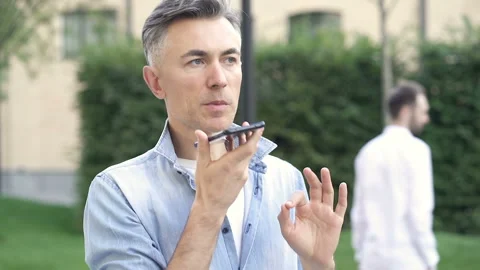 Man recording voice message, while walking in the park. Stock Footage 139331011