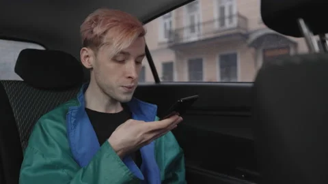 A man records an angry audio message while sitting in a taxi. 스톡 동영상 196100107