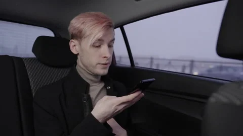 A man records audio message on a smartphone in a taxi. Vidéo 196101302