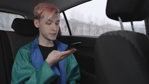 A man records audio message while sitting in a taxi 스톡 동영상 196100239