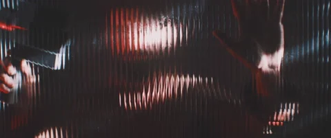 Man in red and shutter lights holding up vintage camera against glass Stock Footage 203573040