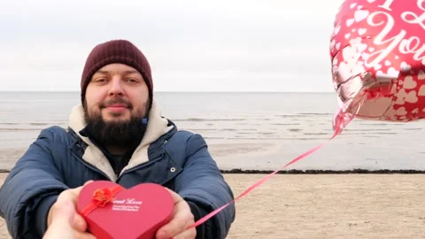 Man with red balloon and gift heart shaped box present Stock Footage 146042443