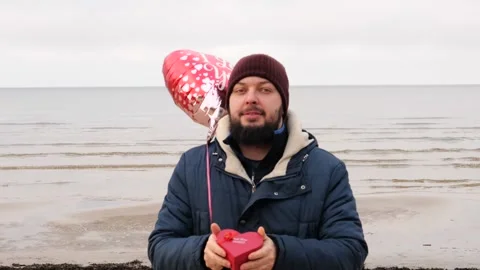Man with red balloon and gift heart shaped box present Video stock 146042707