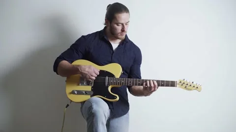 A man, with a red beard and long hair, plays the electric guitar Video stock 153699195