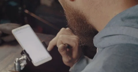 A Man With A Red Beard Clicks On The Screen Of A Mobile Phone. View From Above Stock Footage 121949523