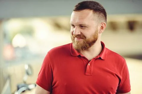 A man with a red beard, dressed in a red gaiety in the city. Happy and health Stock Photos