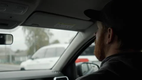 A man with a red beard sits in the front passenger seat during a trip. Stock Footage 253502422