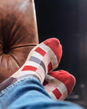 Man with red checkered socks taking a nap with feet up on the sofa Stock-Fotos