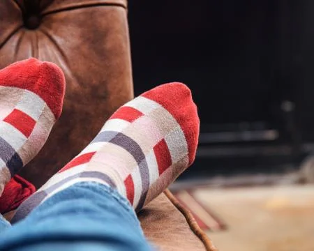 Man with red checkered socks taking a nap with feet up on the sofa Stockfoto's