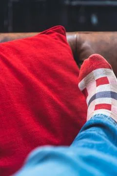 Man with red checkered socks taking a nap with feet up on the couch and red p Stockfoto's