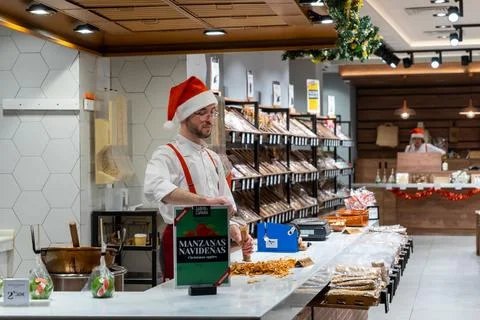 Man in red Christmas hat preparing dessert in Malaga, Spain Stock Photos