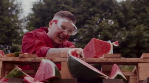 A Man in a red coat slicing some watermelons Stock-Footage 258308640