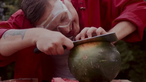 Man in a red coat slicing some watermelons Stock Footage 258309793