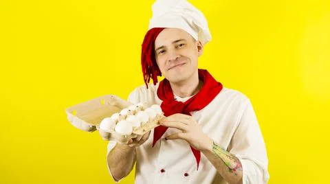 Man with red dreadlocks holds it in his hand chicken eggs. Confident young co Stock Photos