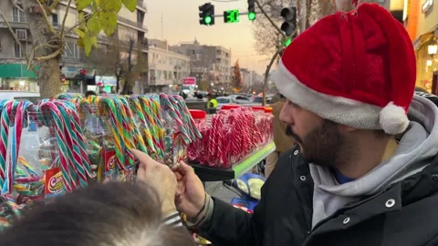 Man with red hat is selling candy cone sweets in Tehran Iran Christmas market Stock Footage 338171586
