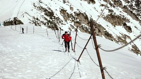 A man in red jacket and sunglasses running on deep snow Stock Footage 103152481