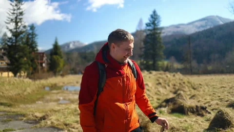 Man in red jacket exploring open field with curious and adventurous mood, natura Stock Footage 337897131