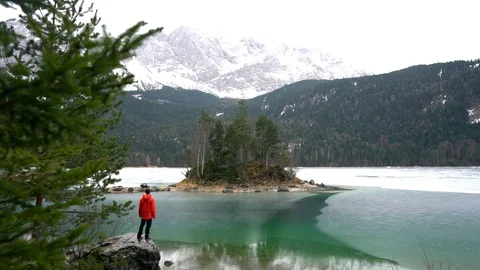 Man in red jacket looking over frozen lake. Stock Footage 125850537