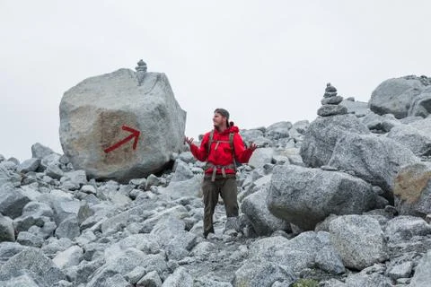 Man in red jacket lost on obvious trail Stock Photos