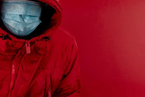 Man in red jacket is using a protective mask against corona virus on red back Stock Photos