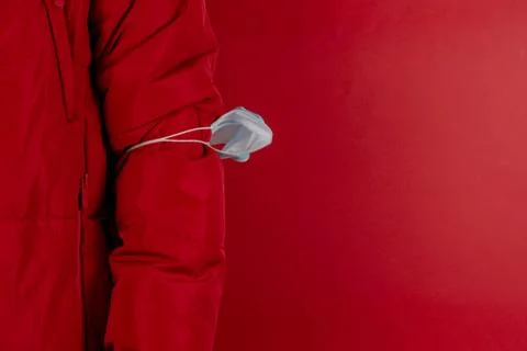 Man in red jacket is using a protective mask against corona virus on red back Stock Photos