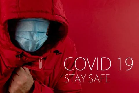 Man in red jacket is using a protective mask against corona virus on red back Stock Photos